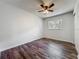 Bedroom showcasing wood-look floors, ceiling fan, and a window for natural light and ventilation at 1905 Selleen Dr, Eustis, FL 32726