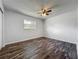 Bedroom displaying wood-look floors, a ceiling fan, and a window providing natural light and outdoor views at 1905 Selleen Dr, Eustis, FL 32726