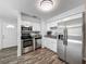 Well-lit kitchen featuring stainless steel appliances, white cabinetry, granite countertops, and wood-look flooring at 1905 Selleen Dr, Eustis, FL 32726