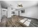 Bright living room with modern lighting, ceiling fan and wood floors seamlessly connected to the kitchen at 1905 Selleen Dr, Eustis, FL 32726