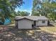 Rear exterior of a well-maintained home, surrounded by mature trees and lush landscaping at 1905 Selleen Dr, Eustis, FL 32726