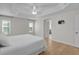 Bedroom featuring tray ceiling, ceiling fan, and wood look floors at 2124 Hames Ln, The Villages, FL 32162