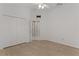 Bright bedroom with wood-look flooring, an closet and an open door at 2124 Hames Ln, The Villages, FL 32162