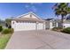Charming single-story home featuring a three-car garage and long driveway at 2124 Hames Ln, The Villages, FL 32162