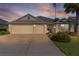 Charming single-story home featuring a three-car garage, well-manicured lawn, and mature palm trees at 2124 Hames Ln, The Villages, FL 32162