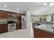 Spacious kitchen features stainless appliances, dark cabinets, and granite countertops at 2124 Hames Ln, The Villages, FL 32162