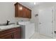 Laundry room featuring a sink, washer and dryer and dark cabinets at 2124 Hames Ln, The Villages, FL 32162