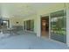 Open screened porch with ceiling fans, outdoor dining area, and sliding glass doors leading inside at 2124 Hames Ln, The Villages, FL 32162