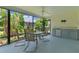 Relaxing screened porch featuring an outdoor dining area, ceiling fan, and convenient kitchenette at 2124 Hames Ln, The Villages, FL 32162