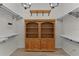 Spacious walk-in closet featuring custom shelving and a built-in wooden armoire at 2124 Hames Ln, The Villages, FL 32162