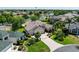 Expansive aerial view of a well-maintained home with a three-car garage, lush landscaping, and a paved driveway at 2237 Avon Loop, The Villages, FL 32162
