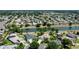Aerial view of a neighborhood featuring waterfront homes, mature trees, and well-manicured lawns at 2237 Avon Loop, The Villages, FL 32162