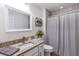 Well-lit bathroom with granite countertop, white vanity and shower with gray tile at 2237 Avon Loop, The Villages, FL 32162
