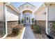 Inviting front entrance with brick-paved walkway and well-manicured landscaping leading to an arched front door at 2237 Avon Loop, The Villages, FL 32162