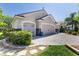 Lovely home features a paver driveway, mature landscaping, and a two-car garage at 2237 Avon Loop, The Villages, FL 32162