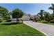 Well-maintained home featuring lush landscaping, a paver driveway, and an attached garage at 2237 Avon Loop, The Villages, FL 32162