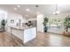 Bright open kitchen with white cabinets, stainless appliances, a large island, and wood-look floors at 2237 Avon Loop, The Villages, FL 32162