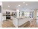 Bright kitchen featuring white cabinetry, a large center island, stainless steel appliances, and hardwood floors at 2237 Avon Loop, The Villages, FL 32162