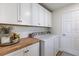 Functional laundry room with ample cabinet space, washer, dryer, and countertop at 2237 Avon Loop, The Villages, FL 32162