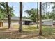 Rear exterior view of the home featuring a screened patio and large yard with mature trees at 227 Oak Rd, Winter Springs, FL 32708
