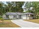 Charming single-story home with attached garage, well-maintained lawn, and a long driveway at 227 Oak Rd, Winter Springs, FL 32708