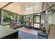 Relaxing screened patio featuring tile flooring, modern furniture, and views of the manicured backyard at 227 Oak Rd, Winter Springs, FL 32708