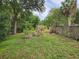 Lush backyard featuring green grass, trees, and a wooden fence, ideal for outdoor enjoyment at 26 Weston Rd, Leesburg, FL 34748