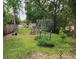 A backyard displays raised garden beds with trellises surrounded by lush vegetation at 26 Weston Rd, Leesburg, FL 34748