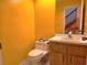 Powder room with yellow walls and a vanity with a single sink and wood cabinets at 26 Weston Rd, Leesburg, FL 34748