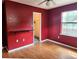 Bedroom featuring red walls, laminate flooring, a shelf, a ceiling fan, and natural light at 26 Weston Rd, Leesburg, FL 34748