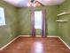 Bedroom with hardwood floors, shelves, and green walls at 26 Weston Rd, Leesburg, FL 34748