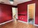 Bedroom with red walls, laminate flooring, ceiling fan, and walk-in closet at 26 Weston Rd, Leesburg, FL 34748