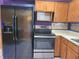 Close up image of stainless steel oven and black refrigerator at 26 Weston Rd, Leesburg, FL 34748