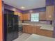 Kitchen with wooden cabinets, black appliances and unique backsplash at 26 Weston Rd, Leesburg, FL 34748