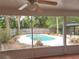 View of a pool and backyard from a screened-in lanai with tile flooring at 26 Weston Rd, Leesburg, FL 34748