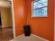 This laundry room has orange walls with a window and ceramic tile floor at 26 Weston Rd, Leesburg, FL 34748