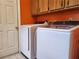 Clean laundry area featuring a white washer and dryer and overhead cabinets at 26 Weston Rd, Leesburg, FL 34748
