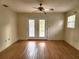 Bright living room boasts hardwood floors, ceiling fan, and double doors to backyard at 26 Weston Rd, Leesburg, FL 34748