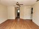 Living room featuring laminate floors, neutral walls, ceiling fan, and a connecting hallway at 26 Weston Rd, Leesburg, FL 34748