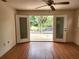 Bright room boasts hardwood floors, ceiling fan, and double doors to outdoor deck at 26 Weston Rd, Leesburg, FL 34748