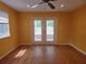Living room showing wood flooring and glass patio doors with a backyard view at 26 Weston Rd, Leesburg, FL 34748