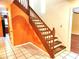 View of staircase with wood banister and vintage orange wall design at 26 Weston Rd, Leesburg, FL 34748