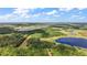 Expansive aerial view capturing multiple lakes amid a sprawling landscape of lush trees and clear blue skies at 27011 Se Highway 42, Umatilla, FL 32784