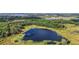 Aerial view featuring a picturesque lake surrounded by dense woods, highlighting the tranquil setting at 27011 Se Highway 42, Umatilla, FL 32784