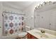 Bright bathroom features shower with patterned curtain and a vanity sink at 27011 Se Highway 42, Umatilla, FL 32784