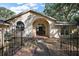 Stunning front exterior of the home with gated courtyard and arched entryway at 27011 Se Highway 42, Umatilla, FL 32784