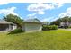 Back yard featuring green lawn, privacy landscaping, and the house at 2750 Coral Reef Way, Tavares, FL 32778