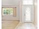 Bright entryway with decorative glass door, tile and wood flooring, and natural light streaming through the adjacent window at 2750 Coral Reef Way, Tavares, FL 32778
