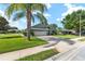 Well-maintained home with a two-car garage, lush green lawn, and mature palm trees at 2750 Coral Reef Way, Tavares, FL 32778