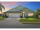 Charming single-story home with manicured lawn, mature landscaping, and a two-car garage at 2750 Coral Reef Way, Tavares, FL 32778